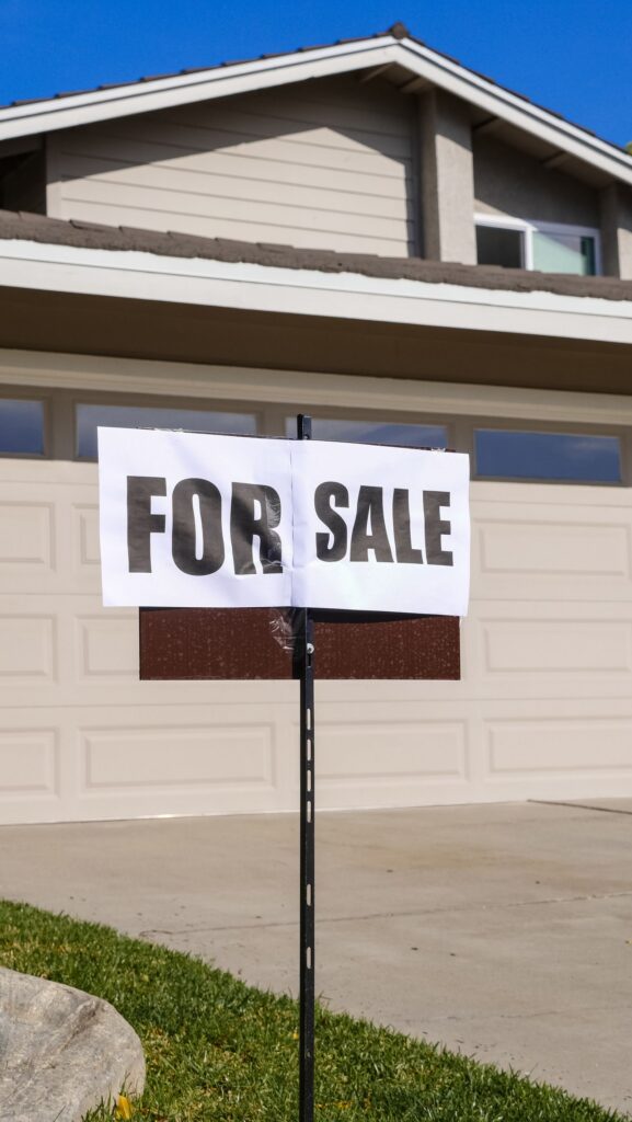 Real estate for-sale sign in front of a home, representing fall pricing strategy