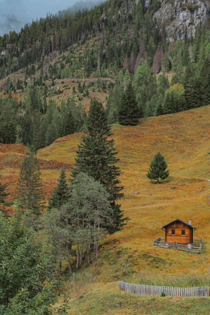 Rustic cabin in autumn mountain landscape, evoking September real estate season